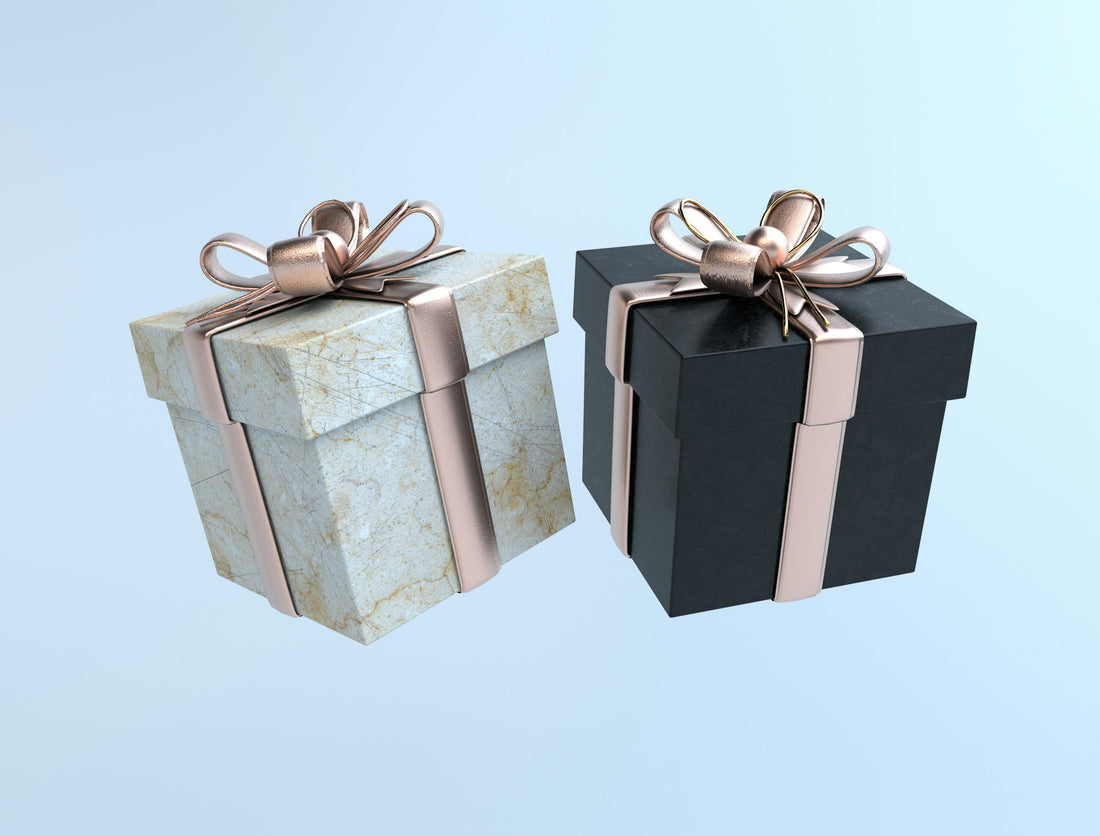 Two gift boxes, one black and one white, tied with gold bows