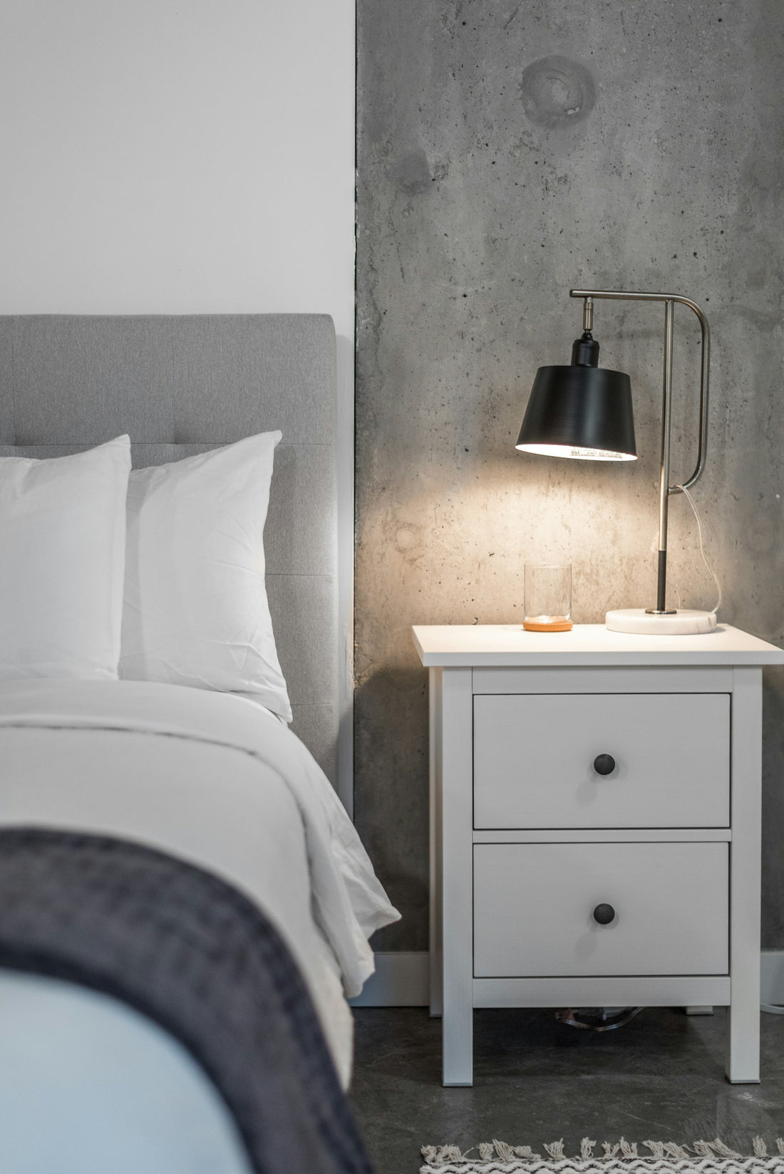 Modern bedroom with a white nightstand and black lamp